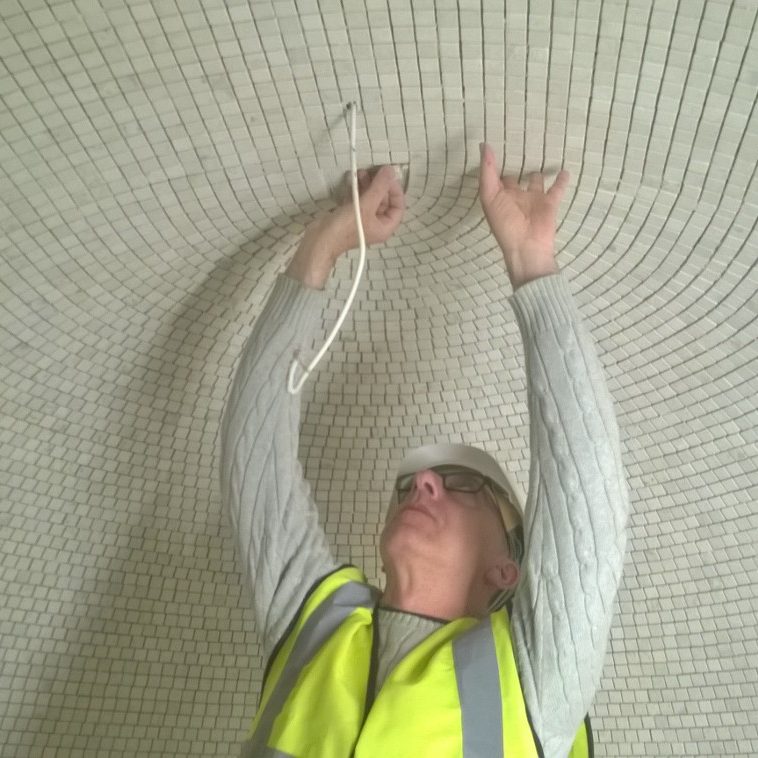 Precision Tiling & Bathroom Installation worker adding small tiles to dome shape room